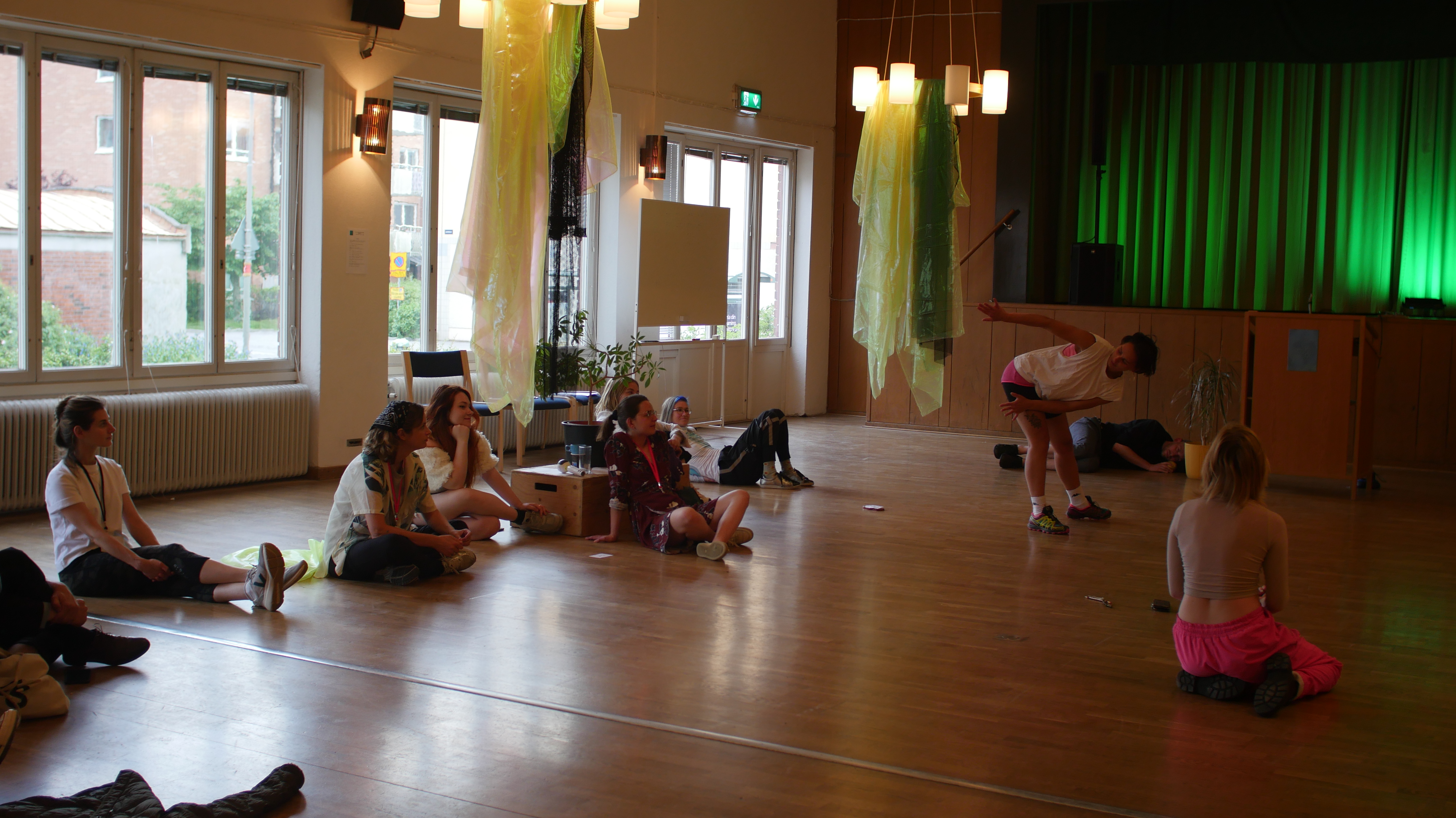 Dancers dancing in a room and people watching